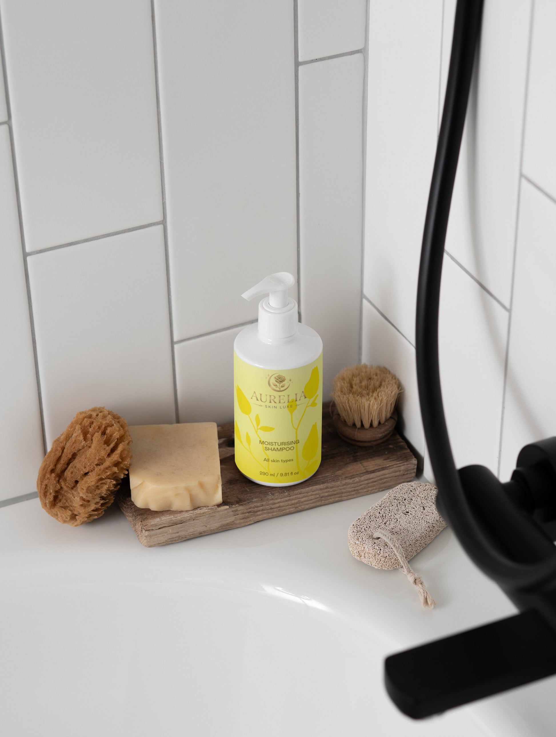 Bathroom counter with a bottle of Elinia Cosmetics product, soap, and sponges.