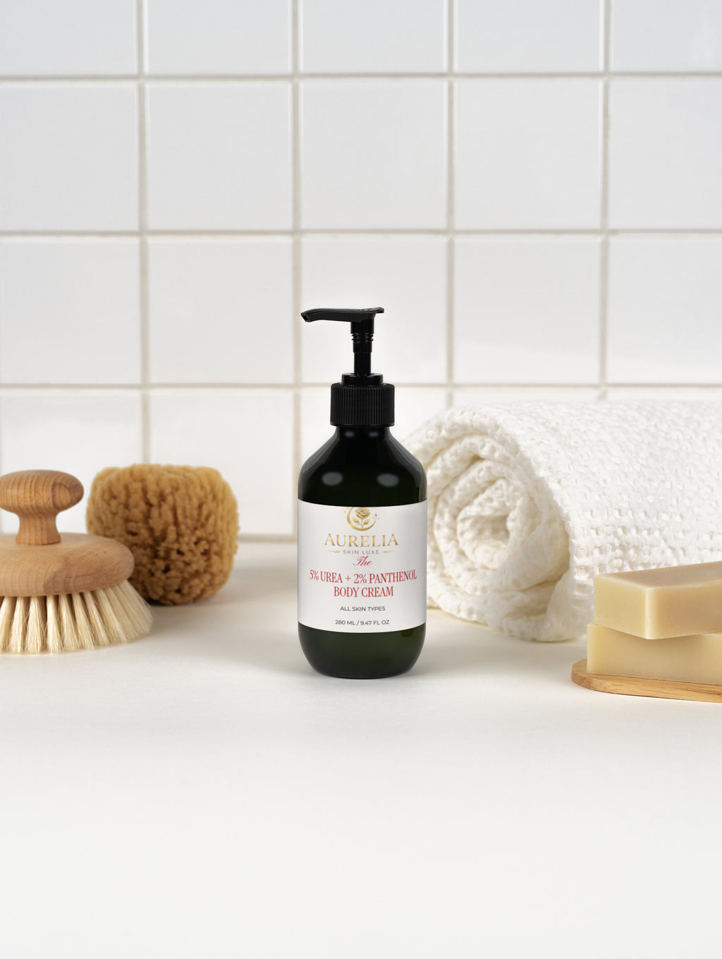 Body cream bottle with a label on a bathroom counter, surrounded by a scrub brush, sponge, and soap.