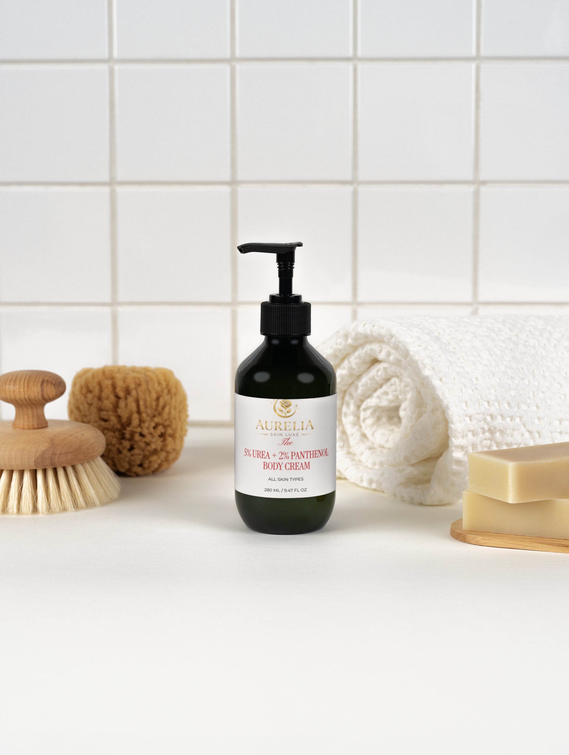 Body cream bottle with a label on a bathroom counter, surrounded by a scrub brush, sponge, and soap.